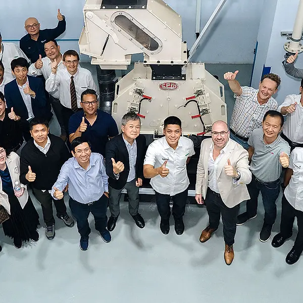 Large group of people smiling, with thumbs up, in the CPM Singapore test lab